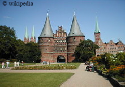 Das Holstentor in Lbeck, im Hintergrund sind die Salzspeicher zu sehen  -   Fr eine grere Darstellung bitte auf das Bild klicken.